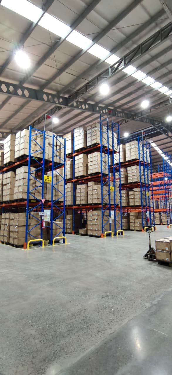 Rak heavy duty TAP menampung volume tinggi barang FMCG dan retail di kedua sisi lorong gudang